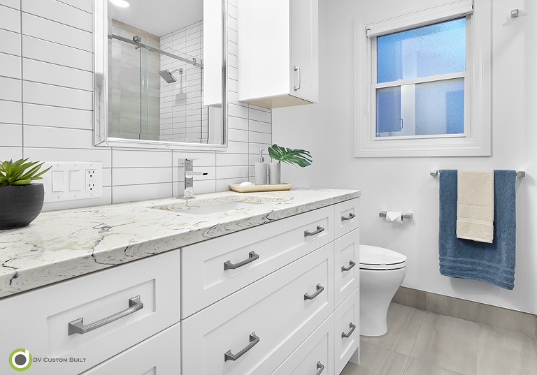 White cabinets, landscape quartz countertop, tiled floor and white subway tiled backsplash